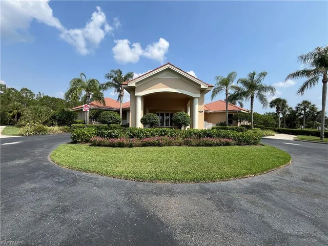 a front view of a house with a yard and potted plants