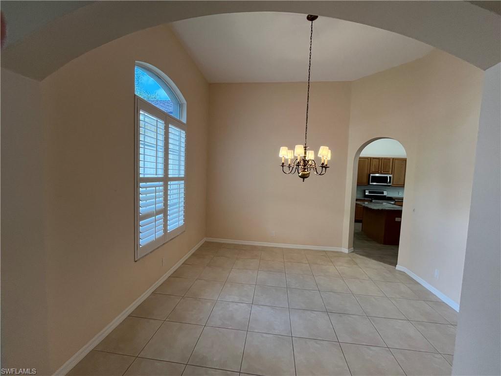 366 Burnt Pine Drive Naples, FL 34119 - Photo 6 of 36 a view of a kitchen with a cabinet and a chandelier
