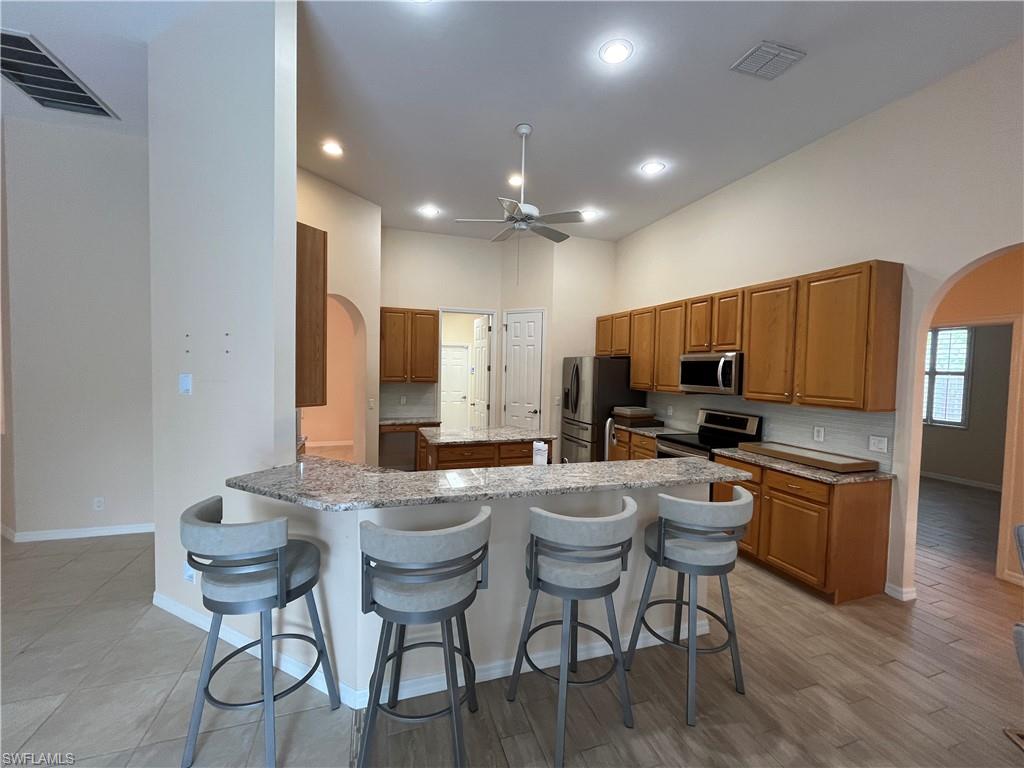 366 Burnt Pine Drive Naples, FL 34119 - Photo 8 of 36 a large kitchen with a table and chairs