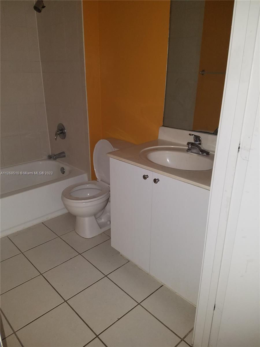 11050 Southwest 196th Street, Unit 305 Miami, FL 33157 - Photo 4 of 9 a bathroom with a toilet a sink and bathtub