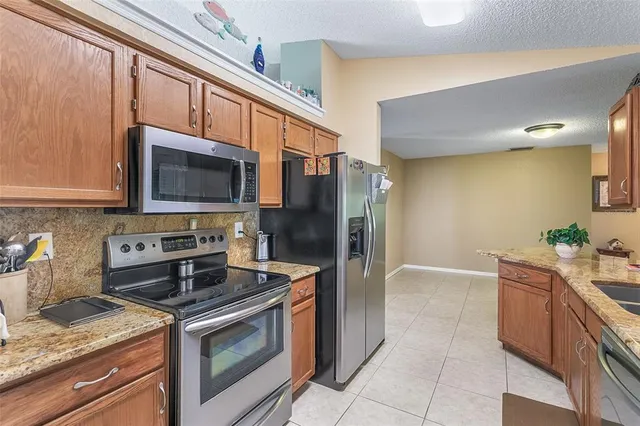 a kitchen with stainless steel appliances granite countertop a stove microwave and refrigerator