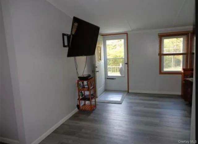 an empty room with window and wooden floor
