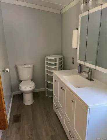 a bathroom with a granite countertop toilet sink and mirror