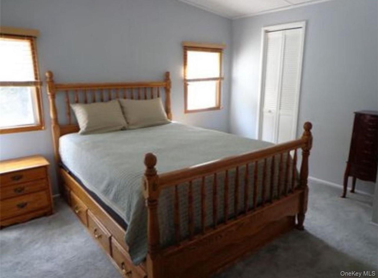 182-184 Mutton Hill Road Neversink, NY 12765 - Photo 16 of 34 a bed sitting in a bedroom next to a window