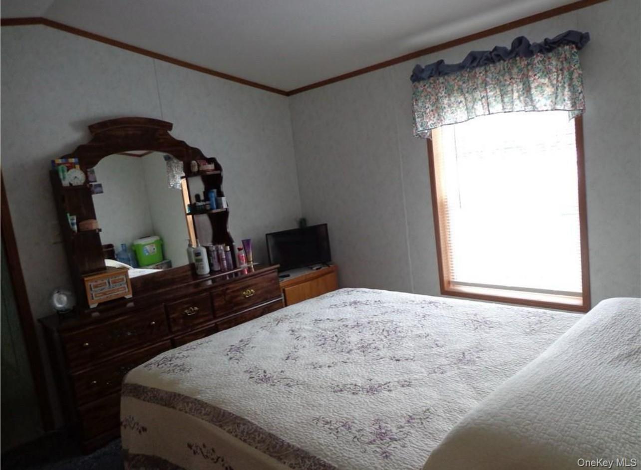 182-184 Mutton Hill Road Neversink, NY 12765 - Photo 34 of 34 a bedroom with a bed and a mirror on dresser