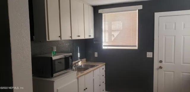 a kitchen with a sink cabinets and window