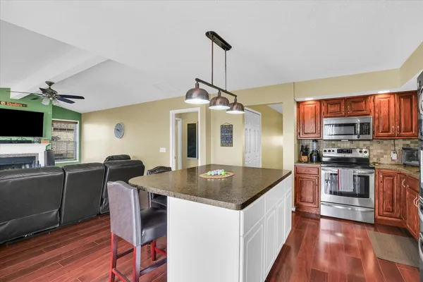 a kitchen with stainless steel appliances granite countertop a stove a sink and a microwave