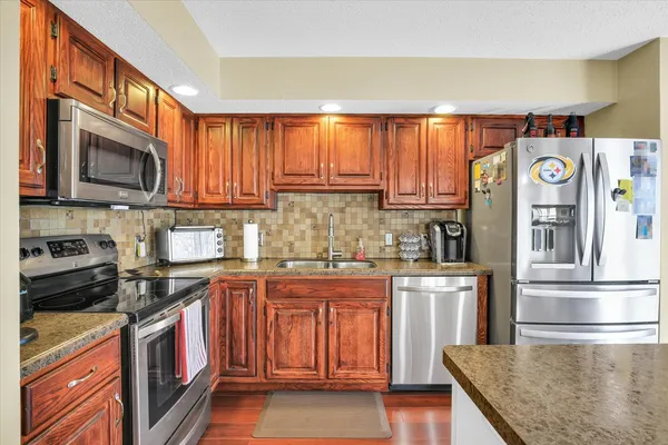 a kitchen with stainless steel appliances granite countertop a sink a stove and cabinets