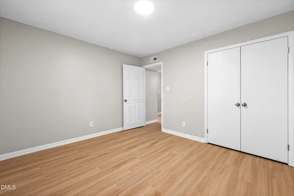 a view of an empty room with wooden floor