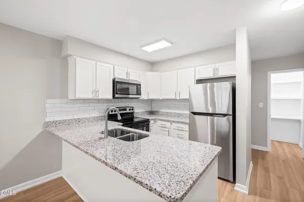 a kitchen with a refrigerator a microwave a sink and a stove