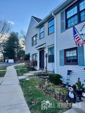 a front view of a house with a yard and potted plants