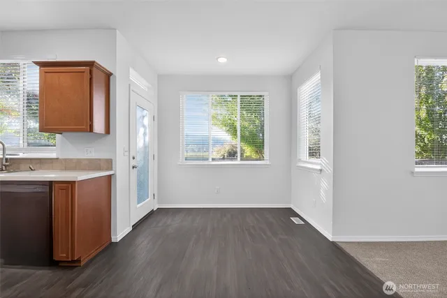 a view of kitchen with wooden floor and electronic appliances