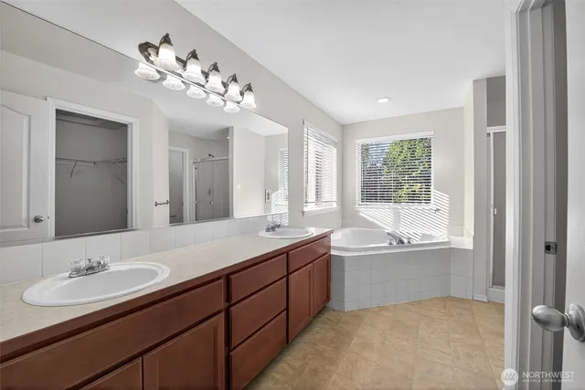 a bathroom with a tub double sink and mirror