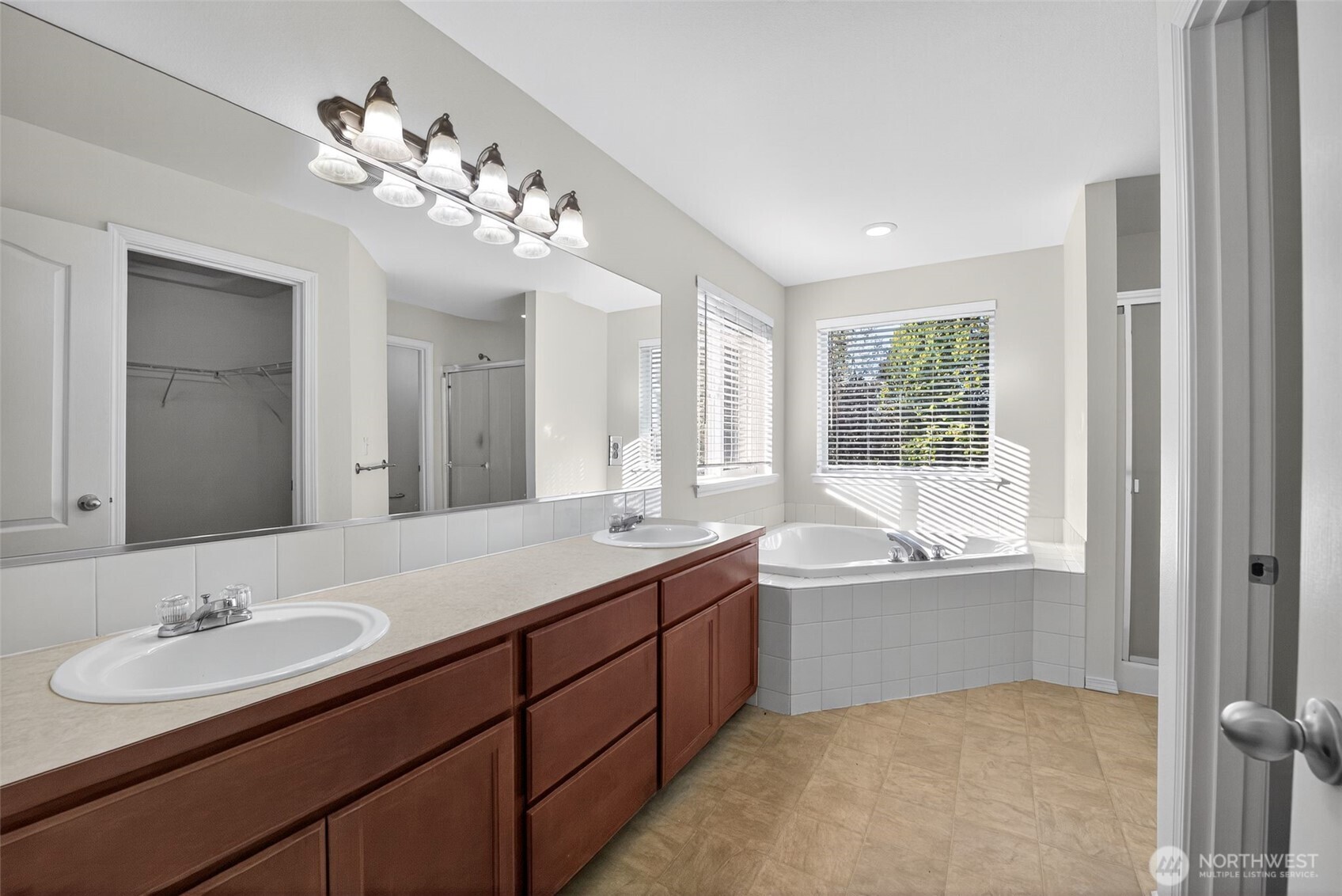 1005 Eagle Avenue Southwest Orting, WA 98360 - Photo 23 of 34 a bathroom with a tub double sink and mirror
