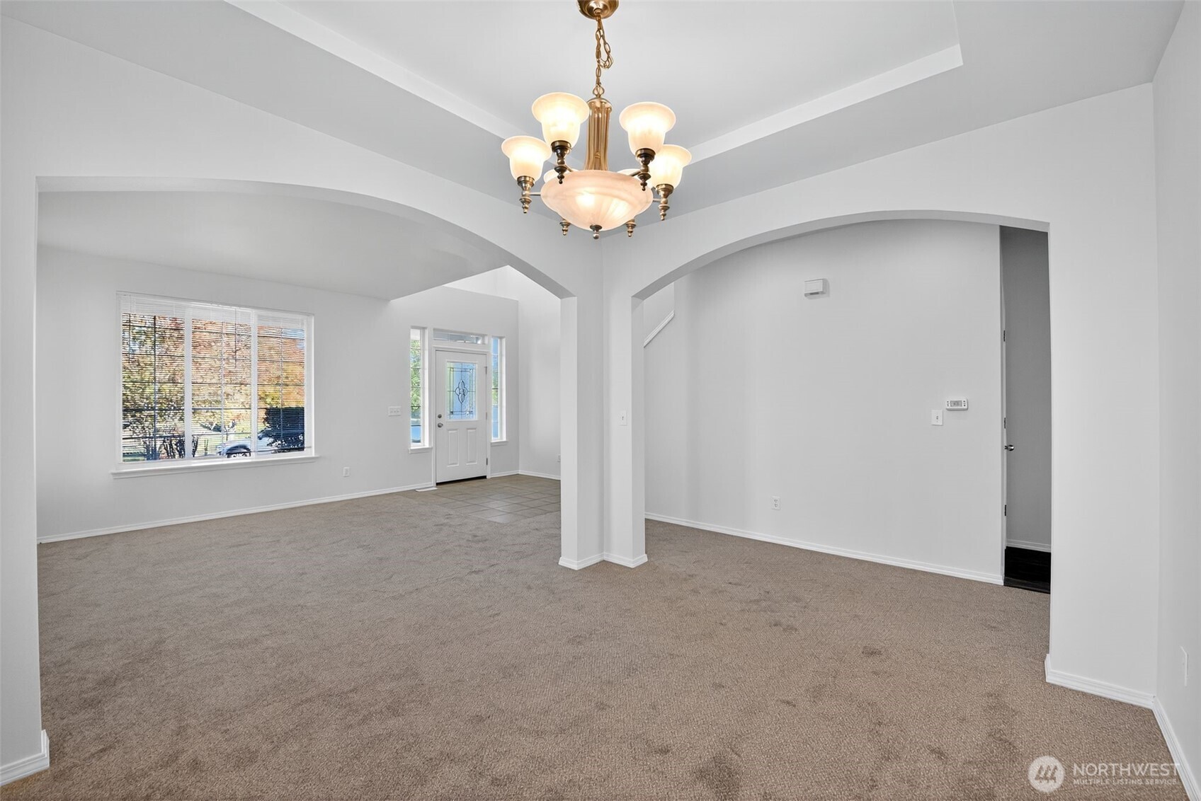 1005 Eagle Avenue Southwest Orting, WA 98360 - Photo 6 of 34 an empty room with windows and chandelier