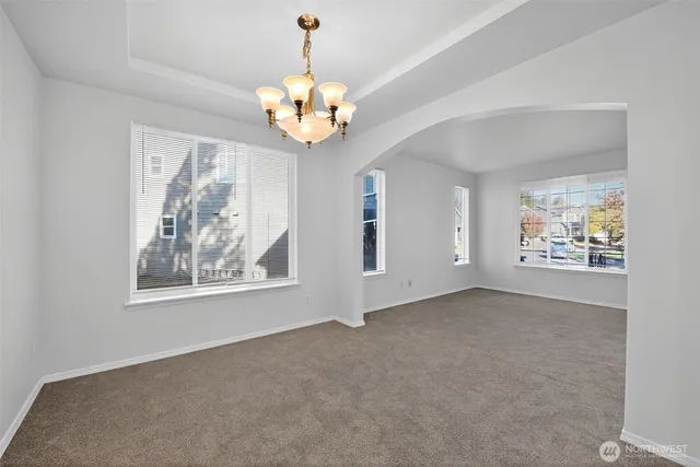 an empty room with windows and chandelier