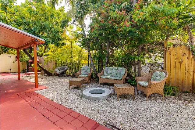 a view of backyard with outdoor seating and trees