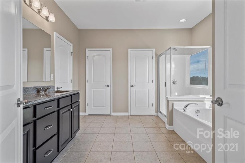 86646 Arrington Road Lancaster, SC 29720 - Photo 31 of 42 a spacious bathroom with a granite countertop sink a mirror and a bathtub