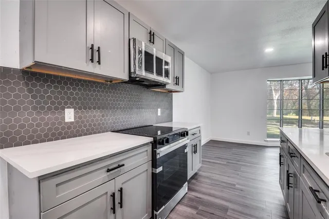 a kitchen with stainless steel appliances granite countertop a stove and a microwave