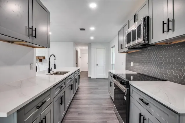 a kitchen with a sink stove and cabinets