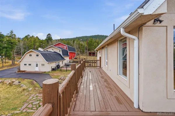 a view of a roof deck with wooden floor and fence with a bench