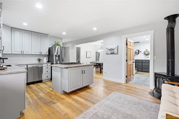 a kitchen with stainless steel appliances granite countertop a sink a stove and a refrigerator