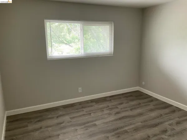 an empty room with wooden floor and closet