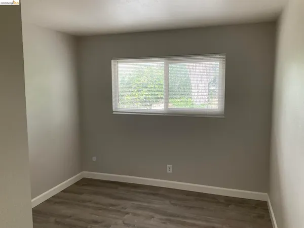 an empty room with wooden floor and closet