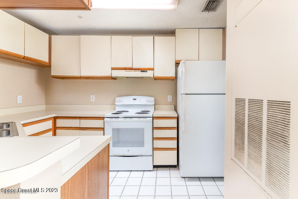 7667 North Wickham Road, Unit 312 Melbourne, FL 32940 - Photo 13 of 47 a kitchen with a refrigerator sink stove and cabinets