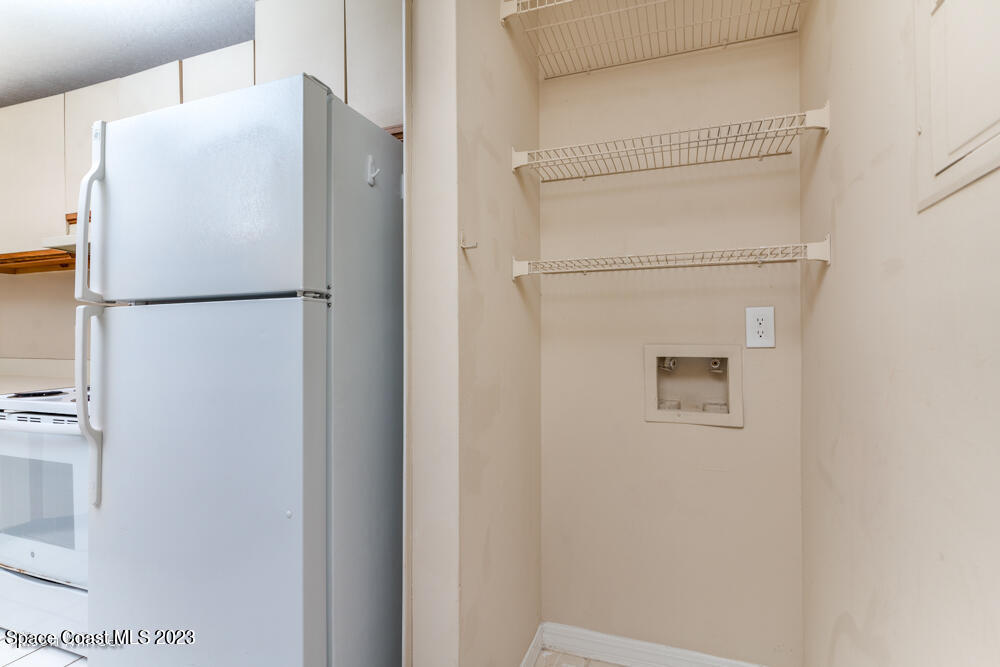 7667 North Wickham Road, Unit 312 Melbourne, FL 32940 - Photo 28 of 47 a white refrigerator freezer and a stove sitting inside of a kitchen