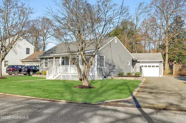 a front view of a house with a yard and trees