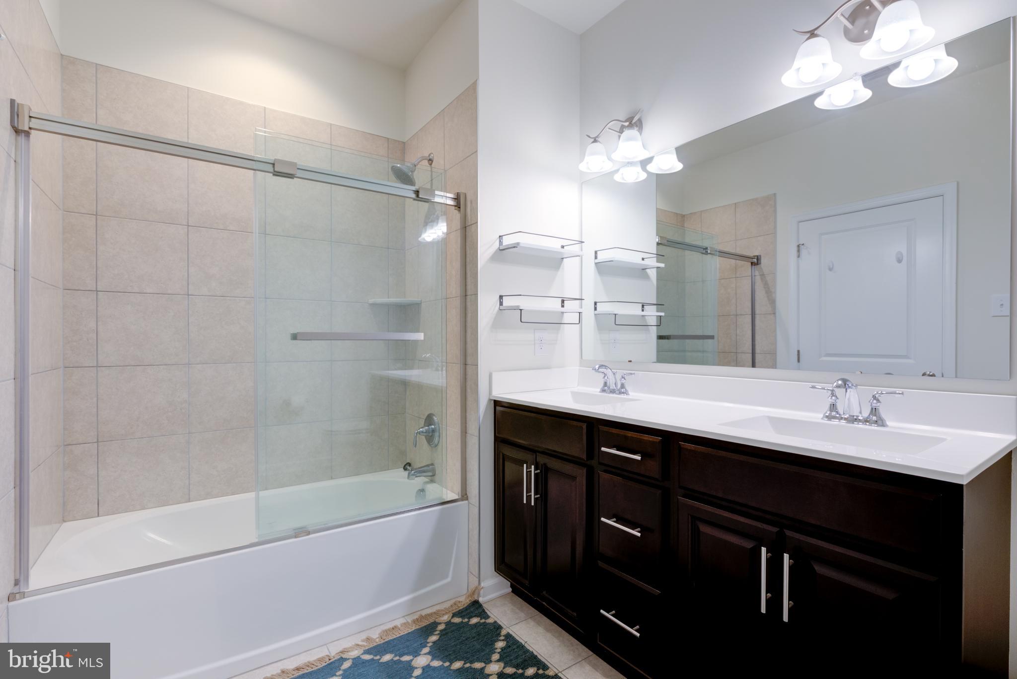 3044 Marias Way Garnet Valley, PA 19060 - Photo 45 of 63 a bathroom with a double vanity sink a large mirror and shower