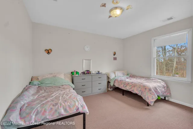 a bedroom with two beds and a painting on the wall