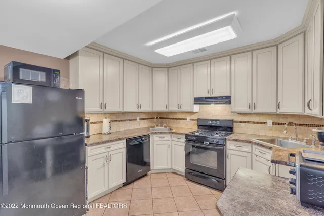 a kitchen with a refrigerator sink and cabinets
