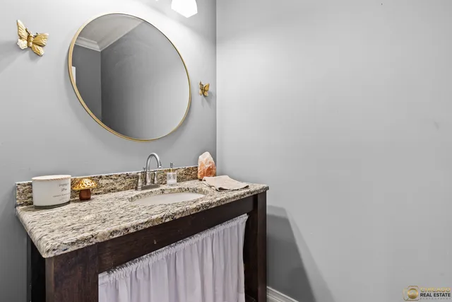 a bathroom with a granite countertop sink and a mirror