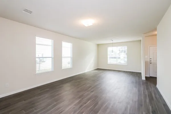 an empty room with wooden floor and window