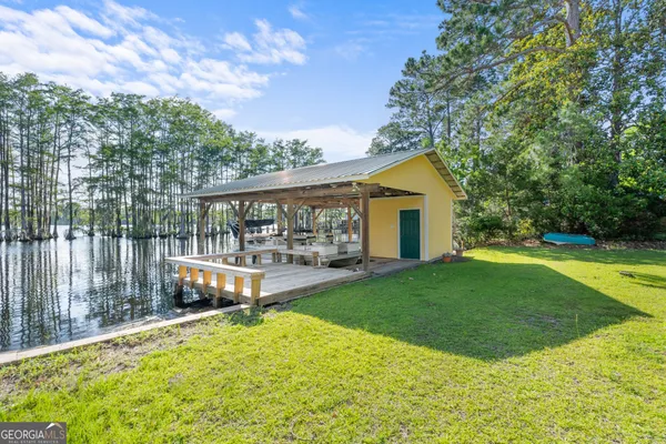 a view of a house with backyard and sitting area
