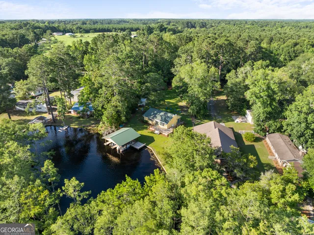an aerial view of a house with a yard and lake view