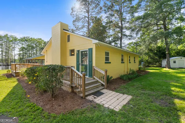 a view of a house with backyard and a tree