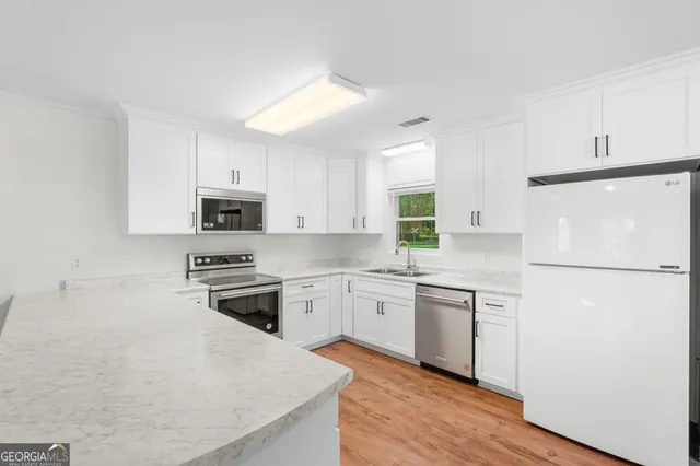 a kitchen with stainless steel appliances a refrigerator stove microwave and sink