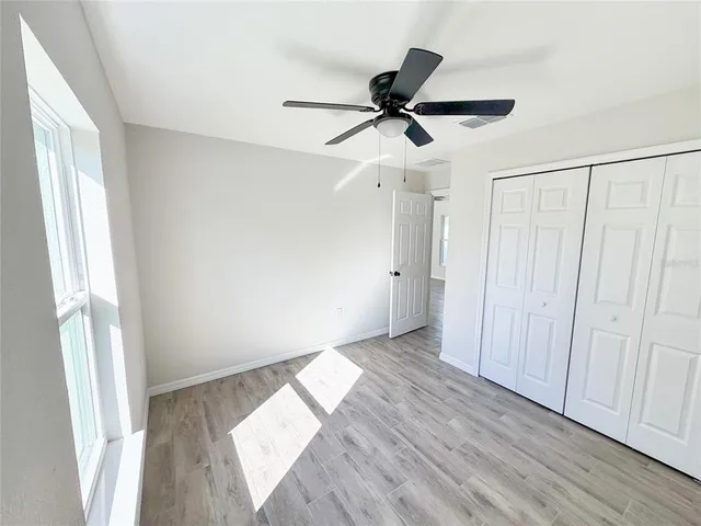 a view of empty room with wooden floor and window