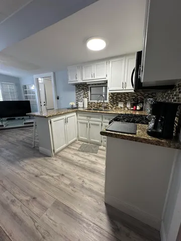 a kitchen with stainless steel appliances granite countertop a stove sink and cabinets