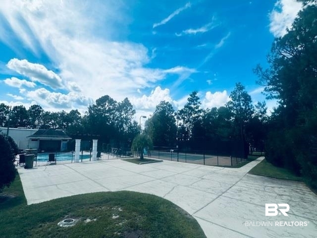 5517 Rabbit Creek Drive Theodore, AL 36582 - Photo 31 of 33 View of yard featuring an outdoor pool, a patio, a tennis court, and view of scattered trees