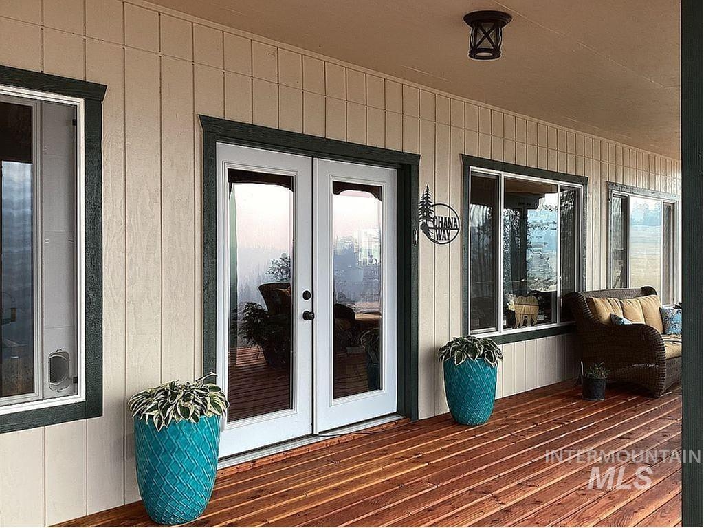 1000 Pardee Road Kamiah, ID 83536 - Photo 11 of 50 Expansive covered porch featuring rich wood-finish decking, multiple large windows, and a set of white French doors