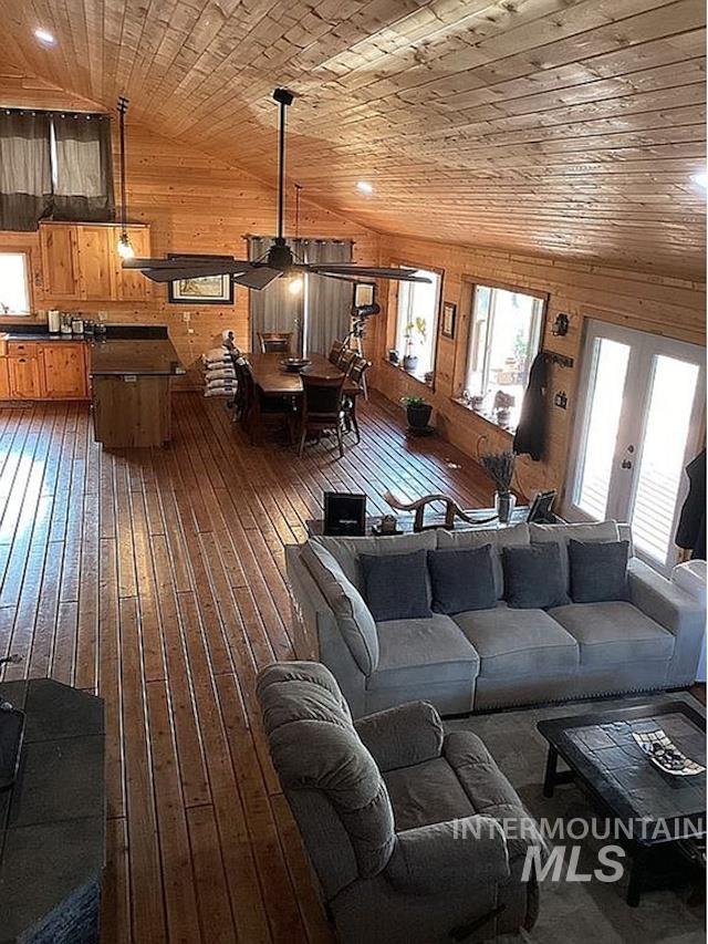 1000 Pardee Road Kamiah, ID 83536 - Photo 16 of 50 Open-concept interior featuring wood-finish flooring and walls, a vaulted wood-paneled ceiling, and multiple windows for natural illumination
