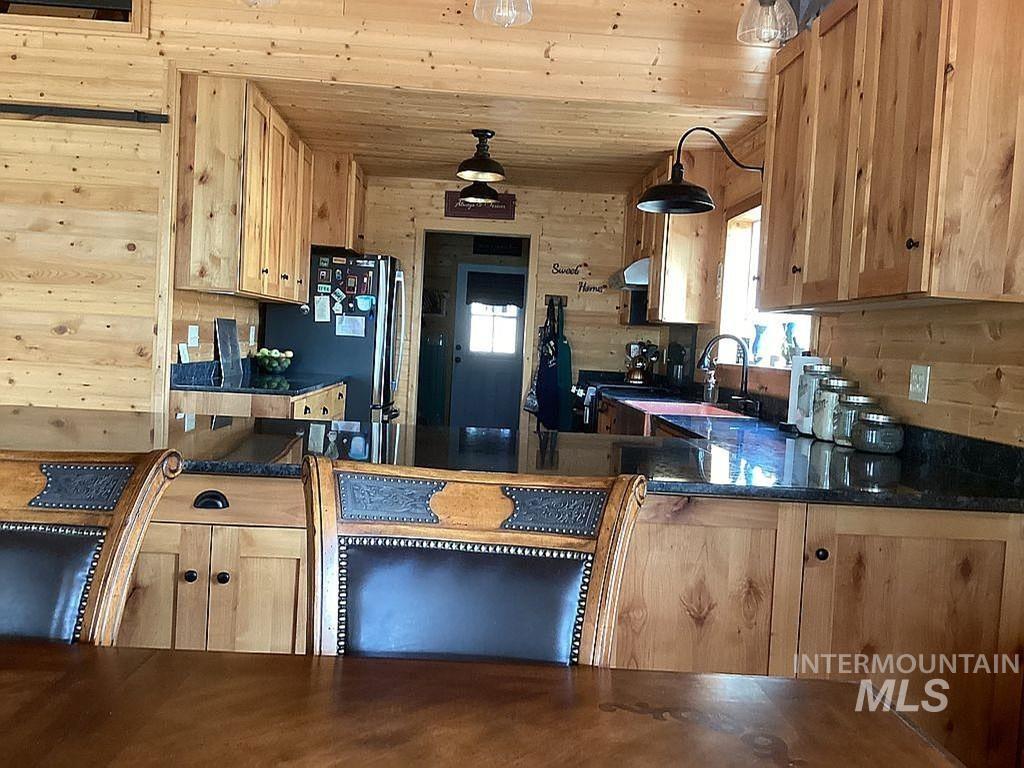 1000 Pardee Road Kamiah, ID 83536 - Photo 19 of 50 Kitchen featuring natural wood plank walls, matching cabinetry, and dark countertops