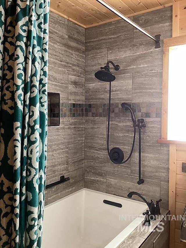 1000 Pardee Road Kamiah, ID 83536 - Photo 27 of 50 Bathtub and shower combination featuring floor-to-ceiling textured tile surround with a decorative mosaic accent band