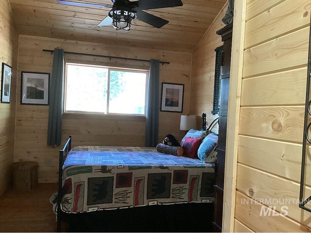 1000 Pardee Road Kamiah, ID 83536 - Photo 29 of 50 Wood-paneled room featuring a sloped ceiling, wood-finish flooring, and a ceiling fan with integrated lighting