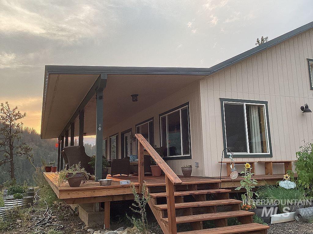 1000 Pardee Road Kamiah, ID 83536 - Photo 3 of 50 Expansive covered wood deck with multiple windows, wood railings, and a view of surrounding terrain