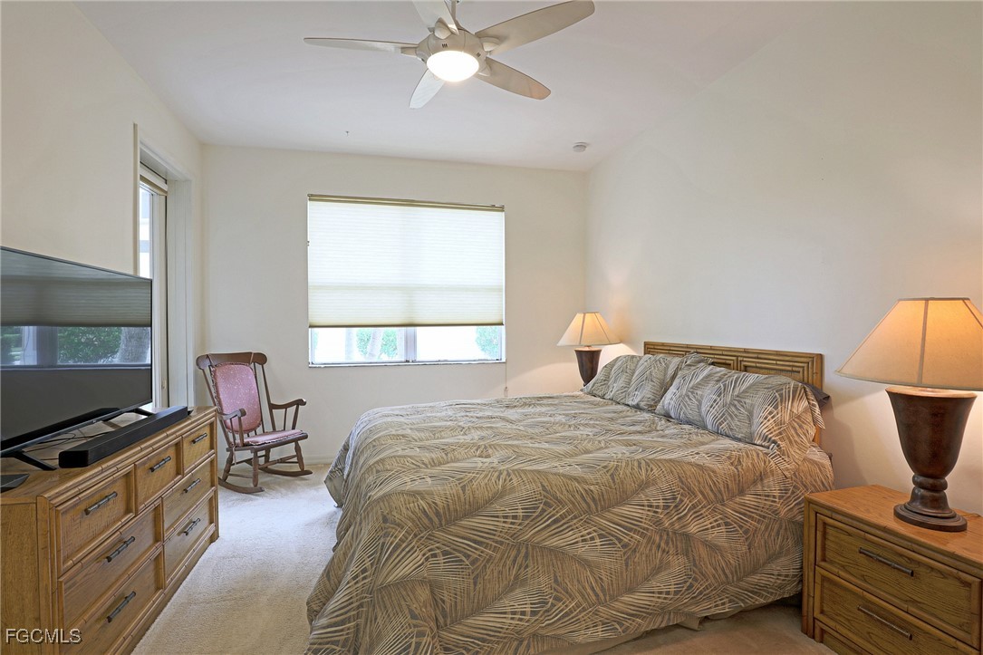 13225 Silver Thorn Loop, Unit 304 North Fort Myers, FL 33903 - Photo 14 of 27 a bedroom with a bed and flat tv screen on the dresser